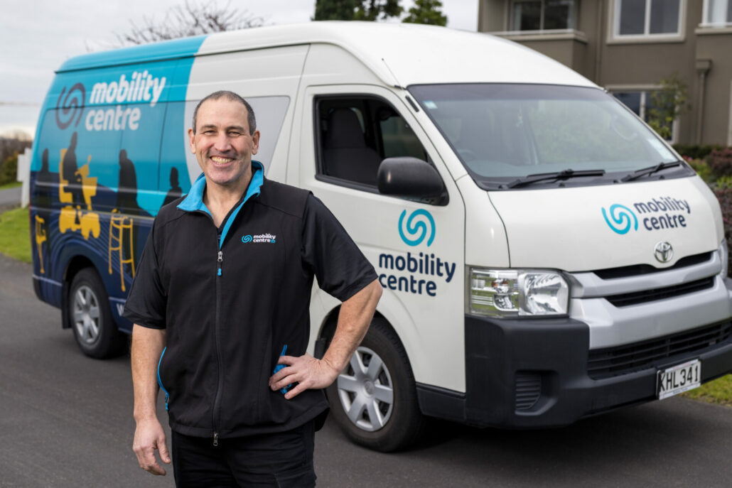 Mobility Centre Technician Ifan stands in front of his service van. He is smiling and ready to help.